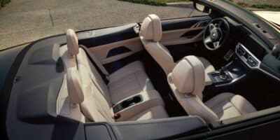 A black bmw hardtop convertible with a creme colored interior.