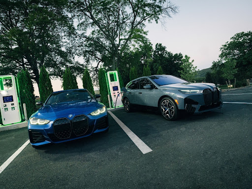 Two bmw hybrid models plugged in at a charging station.