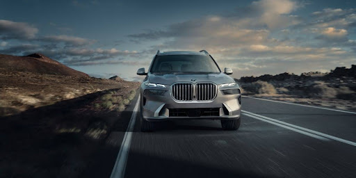 An x7 driving down the highway while people enjoy the bmw x7 interior.