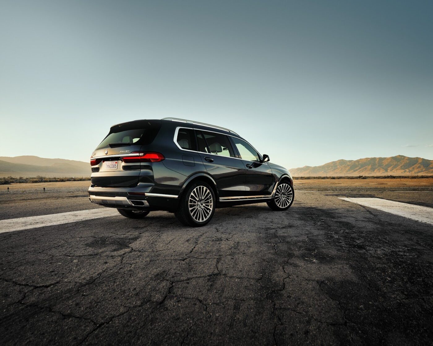 2025 BMW X7 parked on a paved runway with a desert background